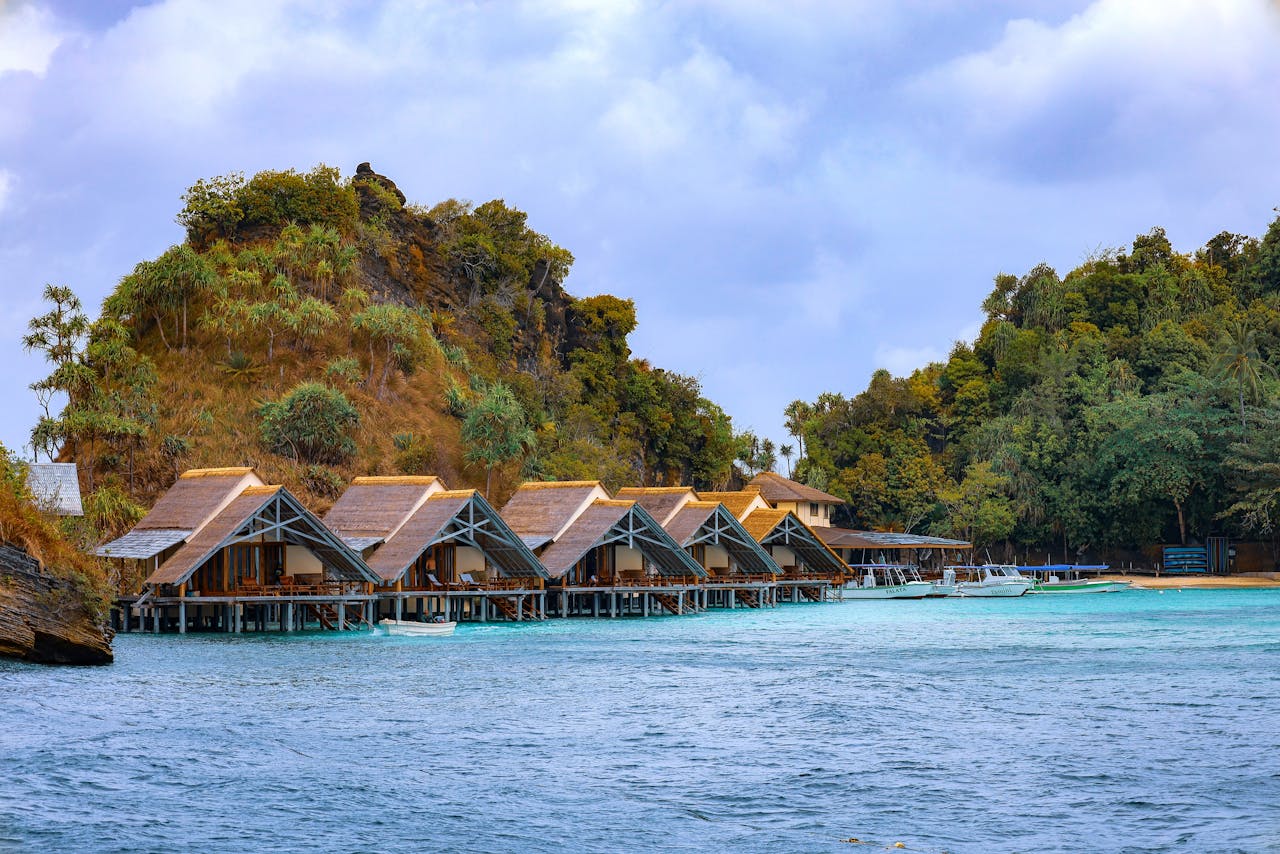 Idyllic overwater bungalows with lush greenery in West Papua, Indonesia. Perfect for a peaceful escape.